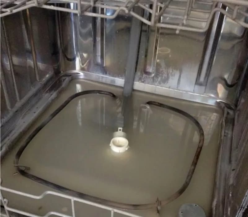 Água parada no fundo de uma máquina de lavar loiça entupida